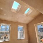 Interior view of existing rear room in St Albans home showing ceiling with skylights and small door before single storey extension begins