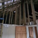 Internal view looking upward into exposed ceiling rafters with original roof structure protected