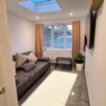 Completed internal view of the converted garage showing a bright home office and living area with skylight and tiled flooring