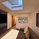 Finished internal view of the converted garage lounge area with skylight, tiled floor and wall-mounted TV