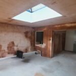 Renovation in progress showing stripped walls and ceilings between lounge and kitchen prior to insulation upgrades