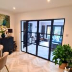 View from dining area through new Crittall-style glazed double doors into lounge with garden doors beyond