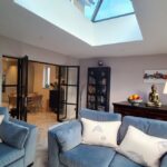View from garden doors through lounge and dining area showing skylight, glazed doors and bright interior