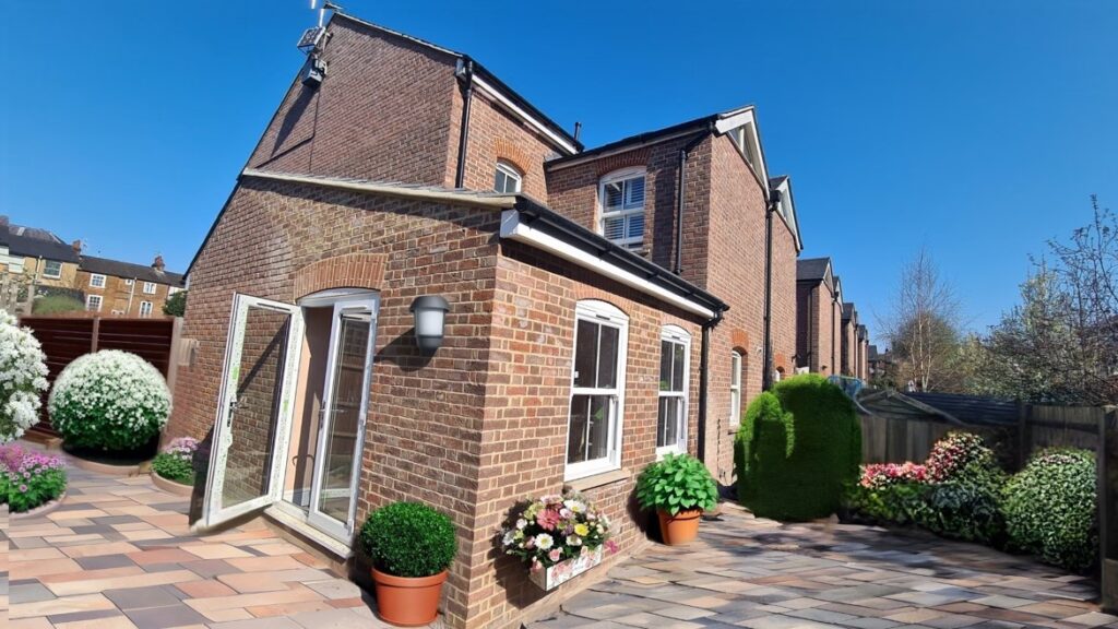 Single storey extension in St Albans showing garden-facing doors, window, and brickwork designed to blend with the existing home.