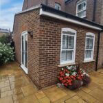 Completed single storey extension in St Albans photographed at 45-degree angle showing corner windows bifold doors and new paving