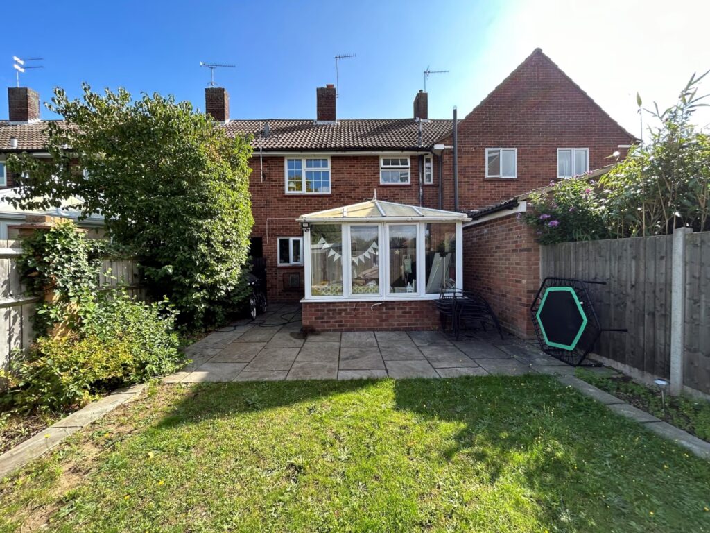 Rear garden view of a mid-terrace home showing an outdated conservatory before extension works began